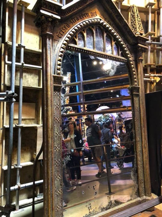 Photo shows a photo of the giant 'mirror of erised' reflecting some of the crowd.