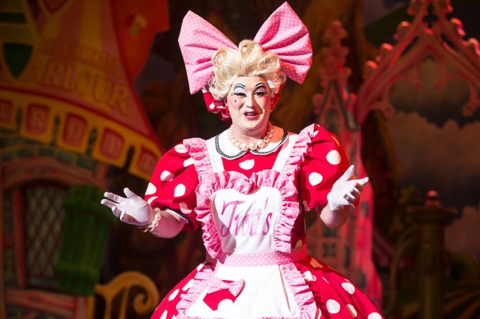 Photo shows Antony-Stuart-Hicks as 'Dolly Trott' she is a red polkadot dress with the base colour being bright red with white dots. She is also wearing a bright pink boe on her head.