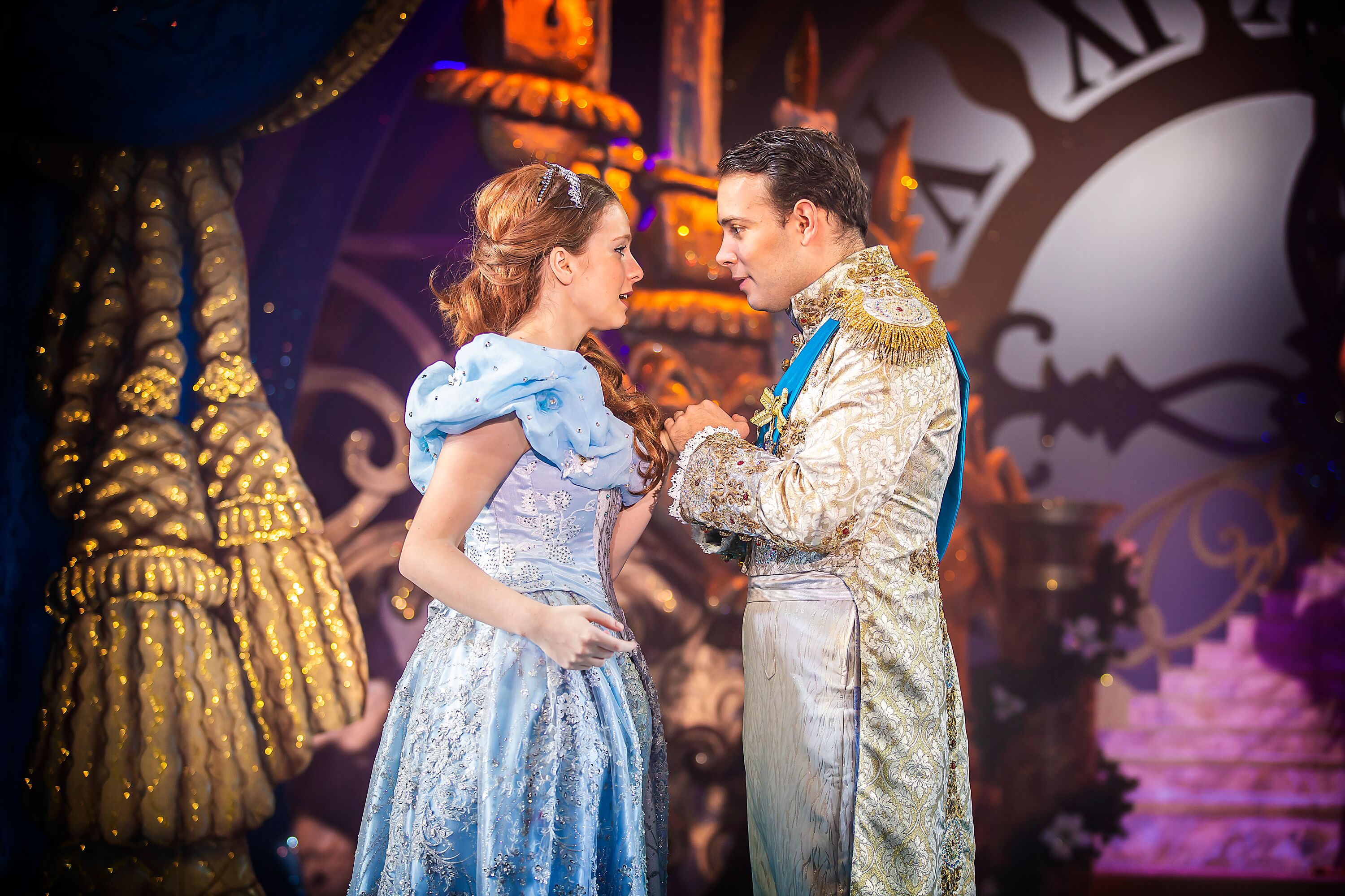 Image shows Cinderella in her sky blue glittery ball gown, and the prince in his ball golden suit gazing into eachothers eyes! Photography By Pamela Raith
