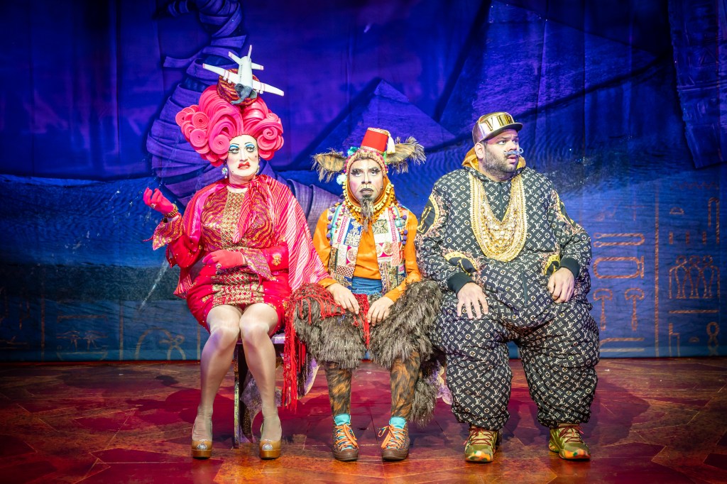 Widow Twankey, Humphrey the Camel & The Emperor of Colchestaria are all sicking on a bench looking all worried and scared.